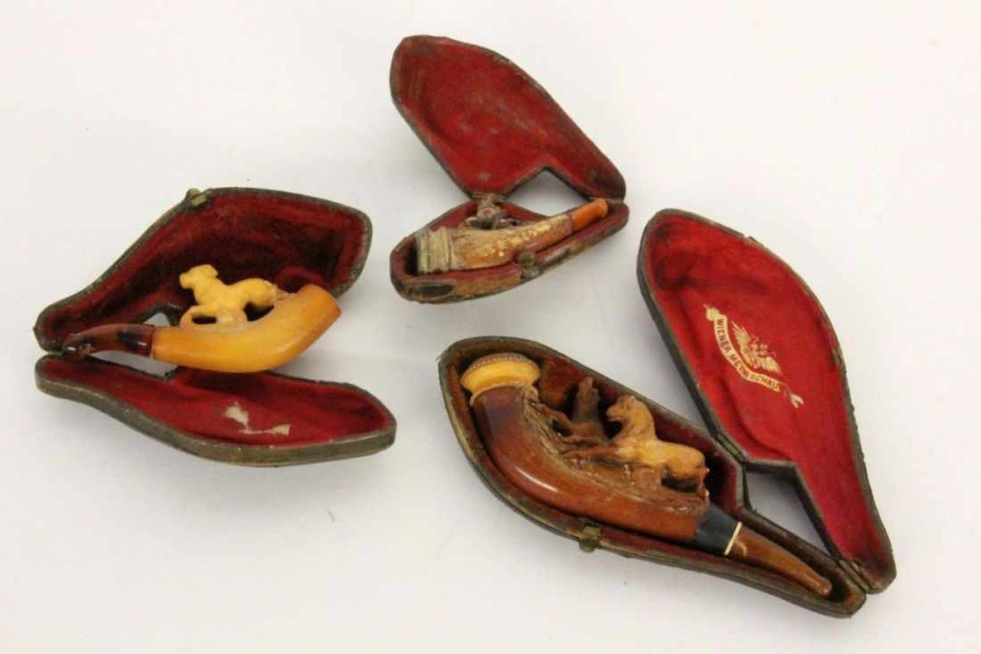 THREE OLD MEERSCHAUM PIPES with leather cases. 7-11.5 cm long. Condition: signs of wear and tear