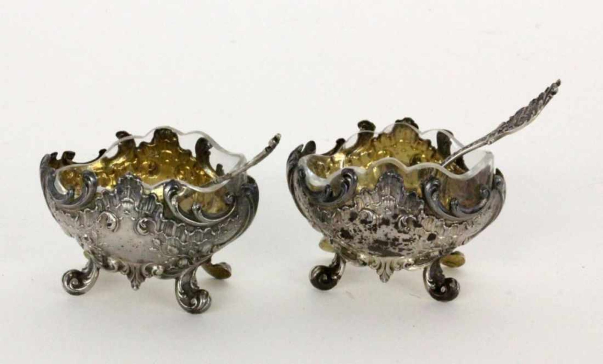 A PAIR OF SALT BOWLS France, 19th century Baroque style. Silver with gilt interior,original glass