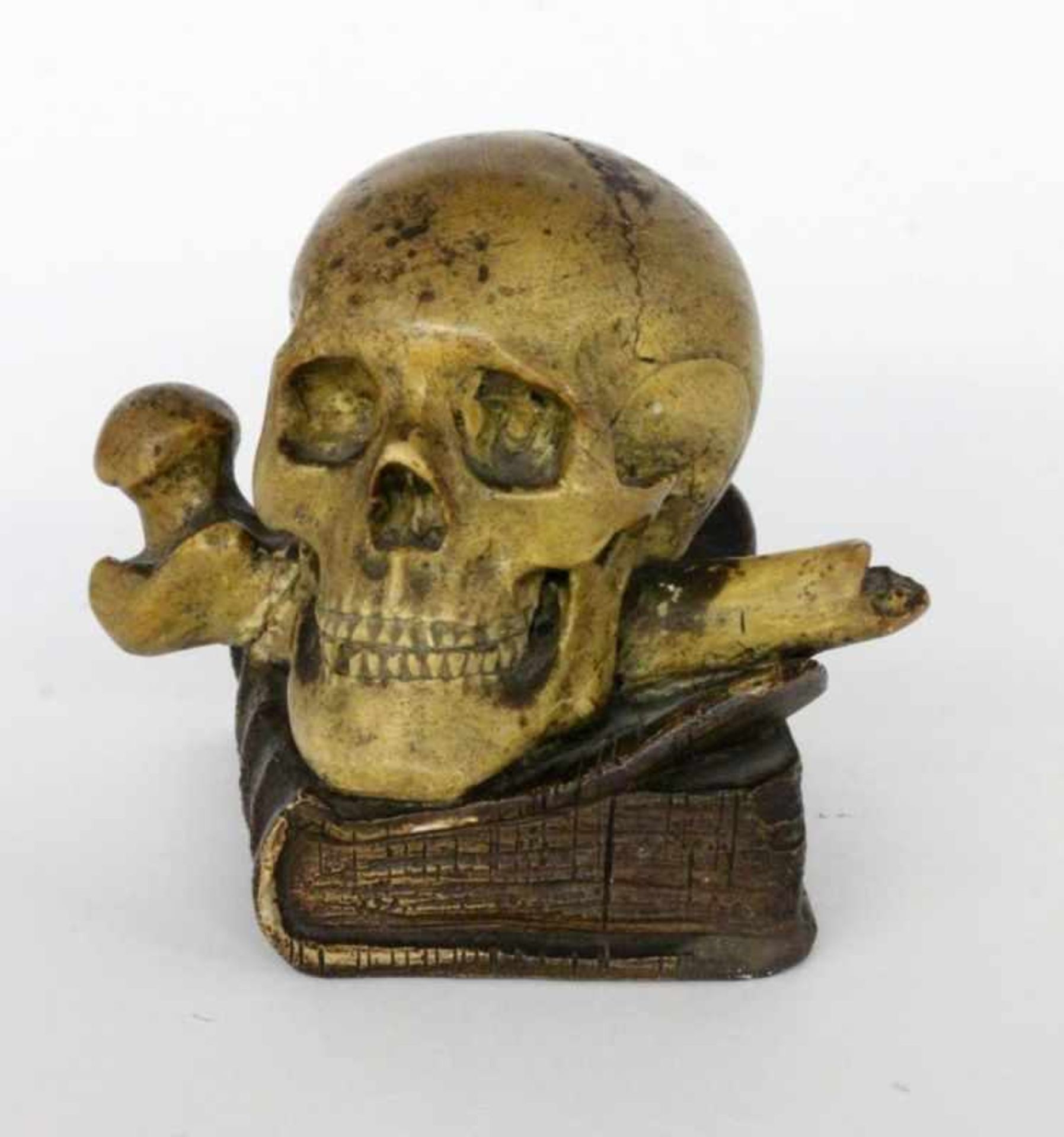 A PAPERWEIGHT WITH SKULL 1st half of 20th century Skull with bones on a book. Terracotta,painted. 11