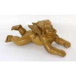 A RECUMBENT PUTTO 20th century Carved wood with clear varnish. 41 cm longLIEGENDER PUTTO20.Jh.