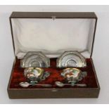 A PAIR OF TEACUPS IN A CASE China Porcelain, painted with red Ming Dragon. Mount, saucersand