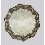 A BAROQUE STYLE TRAY Silver-plated metal, floral engraved and with rocaille edge. 32 cmdiameter.