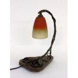 AN ART NOUVEAU TABLE LAMP France, 1920s Floral decorated metal frame on wooden base. Glasstulip with