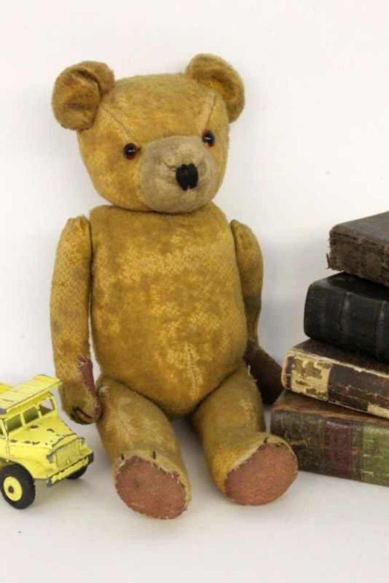AN OLD TEDDY BEAR Yellow fur, glass eyes. 38 cm long.ALTER TEDDYBÄRGelbes Fell, Glasaugen. L.38cm- -