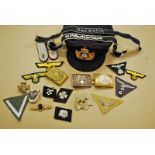 A selection of Nazi style badges including eagles, cuff titles, belt buckles, rank badges and