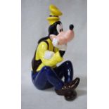 A Schmid Walt Disney figural Musical Character as a seated Goofy, playing Jolly Good Fellow, 28.