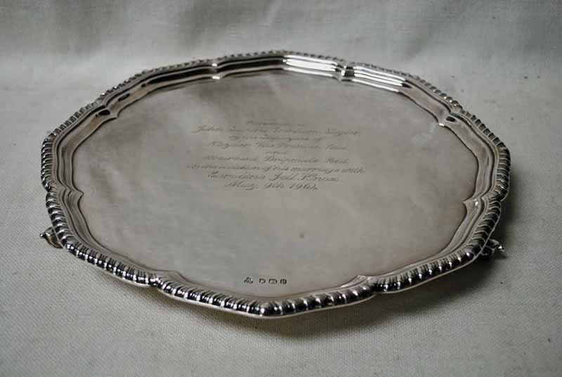 A mid 20th century silver three-footed Tray of shaped circular form supported on scroll feet,