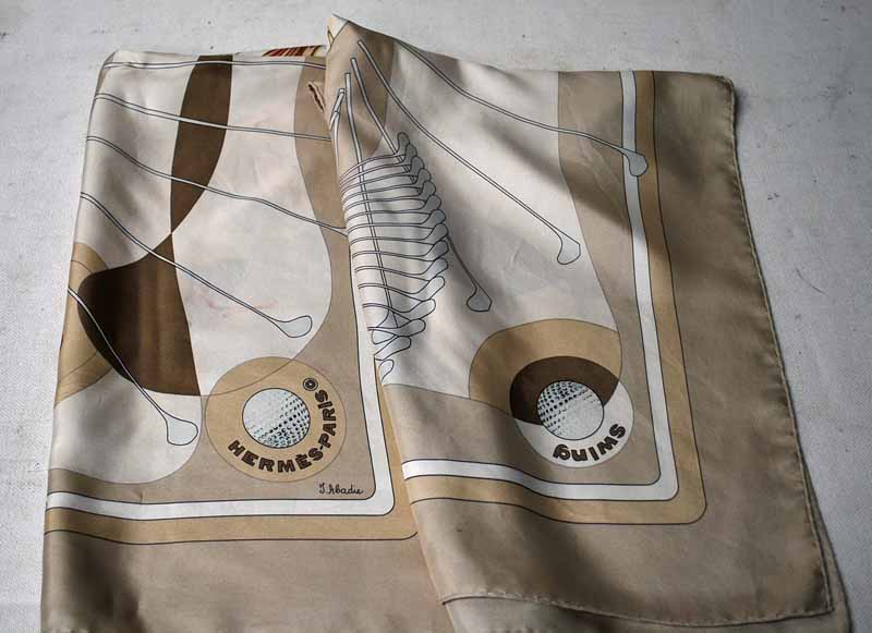 A Hermes of Paris Silk Scarf in the Swing design by J Abadie, the design featuring Golf Clubs and