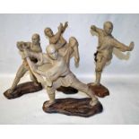 A set of four Japanese clay figures, unglazed, each in a different Tai Chi pose, on naturalistic