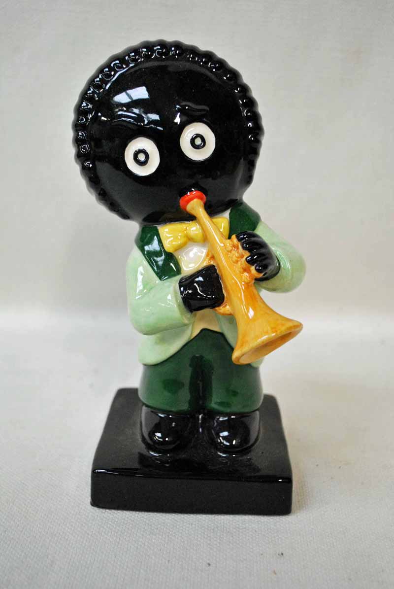 A large Carlton ware figure of a musician modelled as a Golliwog playing a trumpet, light and dark