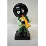 A large Carlton ware figure of a musician modelled as a Golliwog playing a trumpet, light and dark