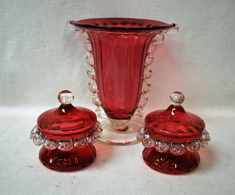 A large early 20th century Cranberry Glass Celery Vase with clear glass wavy sides and a clear foot,