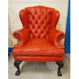 A Georgian style red leather Wing Back Armchair, buttoned upholstery to the back, scroll arms,