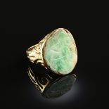 AN 18K YELLOW GOLD AND GREEN JADE RING, hand carved with Chinese symbols, the stone measures