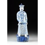 A LARGE CHINESE BLUE AND WHITE PORCELAIN FIGURE OF A QING DYNASTY EMPEROR IN COURT DRESS, the figure