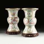 A NEAR PAIR OF FAMILLE ROSE PARCEL GILT ENAMELED PORCELAIN GU VASES ON STANDS, QING DYNASTY (1644-