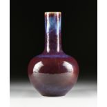 A CHINESE FLAMBÉ GLAZED PORCELAIN BOTTLE VASE, QING DYNASTY (1644-1912), the dark red hued neck