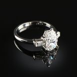 A PLATINUM AND PEAR-SHAPED DIAMOND LADY'S RING, the mounting centering a pear modified brilliant cut