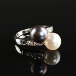 A 14K WHITE GOLD, PEARL, AND DIAMOND LADY'S BYPASS RING, the mounting set with a 7 mm white pearl