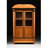 A BIEDERMEIER POLISHED AND EBONIZED FRUITWOOD BOOKCASE CABINET, AUSTRIAN, CIRCA 1825, the triangular