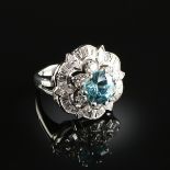 A PLATINUM, BLUE ZIRCON, AND DIAMOND LADY'S RING, the mounting centering a round cut blue Zircon