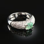 AN 18K WHITE GOLD, EMERALD, AND DIAMOND LADY'S RING, the mounting centering an emerald weighing