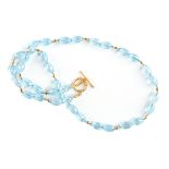 A 22K YELLOW GOLD AND AQUAMARINE LADY'S BEADED NECKLACE, comprising thirty-six oval cut faceted