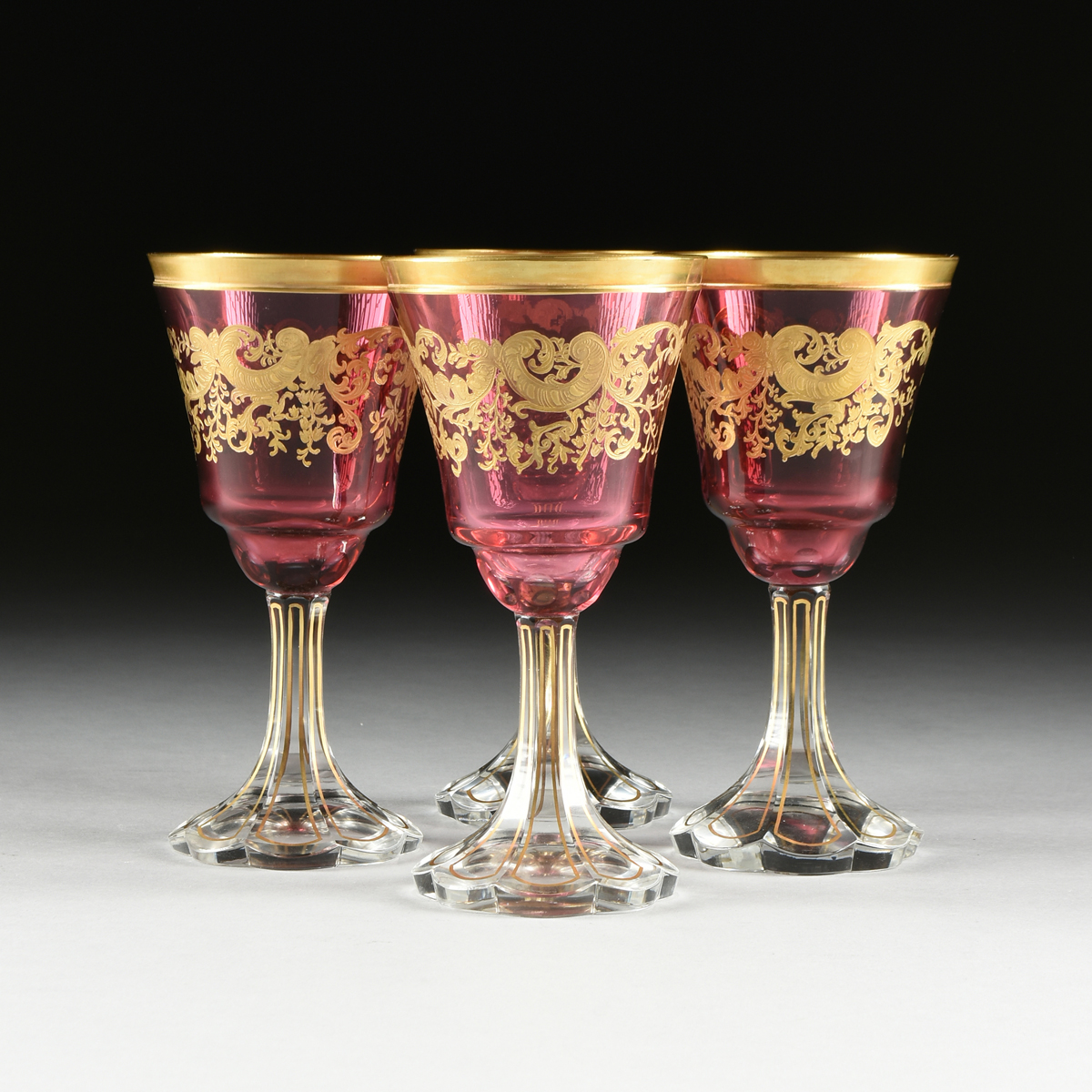 A SET OF FOUR BACCARAT STYLE GILT OVERLAY CRANBERRY TO CLEAR GOBLETS, CIRCA 1900, the gilt rims over - Image 2 of 8