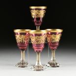 A SET OF FOUR BACCARAT STYLE GILT OVERLAY CRANBERRY TO CLEAR GOBLETS, CIRCA 1900, the gilt rims over