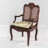 Louis XV Caned Walnut Armchair, France, 18th century, curved crest rail carved with garlands of