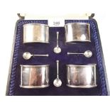 A set of four silver oval salts and four spoons (one matched) with blue glass liners, cased