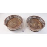 A pair of silver plated on copper bottle coasters with wooden bases