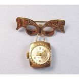 A Cara 9 carat gold nurses watch on 9 carat gold mask form brooch