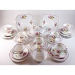 A Shelley floral painted tea service comprising teapot, nine cups and saucers, two cake plates and