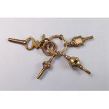 A group of four decorative yellow metal watch keys