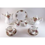 A Royal Albert Country Roses tea service comprising teapot, covered sugar, milk jug, three cake