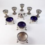 Three silver circular salts (two with liners) and various silver plated egg cups and cruets