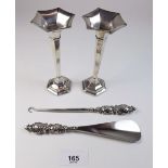 A pair of small silver vases, a silver handled shoe horn and a button hook