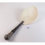 A 19th century spoon or scoop with white metal mounted turned ebony handle