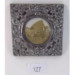 An Edwardian square silver photograph frame with all over scrollwork decoration - 10cm by 10cm