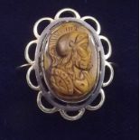 An antique yellow metal ring with carved tigers eye cameo - size N/O