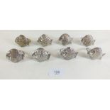 A set of eight metal fish form napkin rings