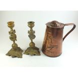 A JS + S copper Art Nouveau embossed lidded jug, and a pair of brass Leprechaun candlesticks