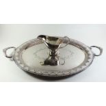 A silver plated oval tray with embossed decoration and a silver plated sauce boat
