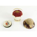 A bone pin cushion in form of a bucket painted roses, another pin cushion and Ledbury souvenir pin