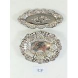 A small silver dish with pierced decoration and another silver dish with embossed decoration to edge