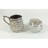 A Kirk & Sons silver jug embossed flowers and a cut glass and silver dressing table pot