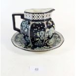 A Royal Doulton black jug and plate decorated blue flowers
