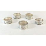 A set of three Edwardian napkin rings and two other silver napkin rings, 66g