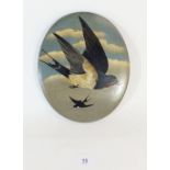 A Victorian terracotta oval plaque painted swallows 25 x 20cm